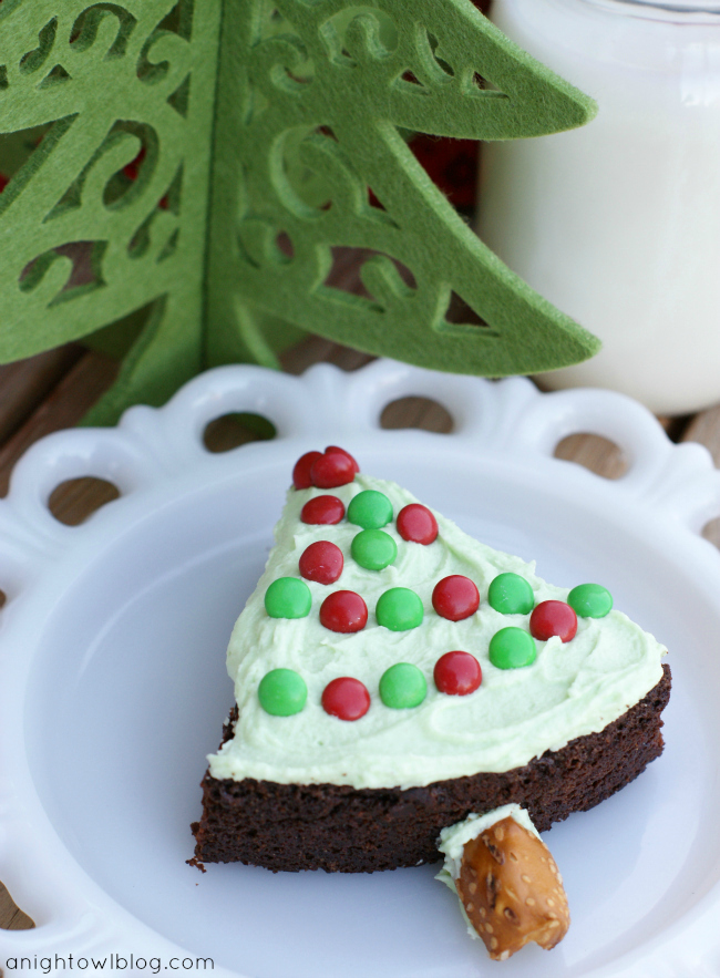 Easy Christmas Tree Brownie Treats! Bake brownies in a round pan, cut into wedges, top with green frosting and Mini M&Ms for lights and add a pretzel for the tree trunk!