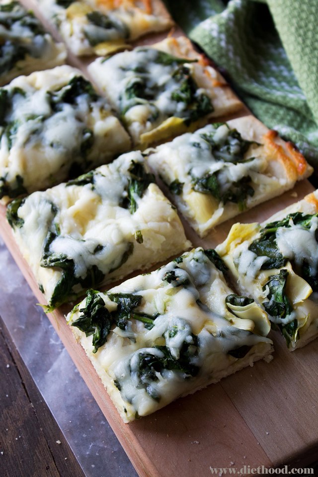 Delicious homemade pizza crust topped with spinach, cream cheese, and artichokes.